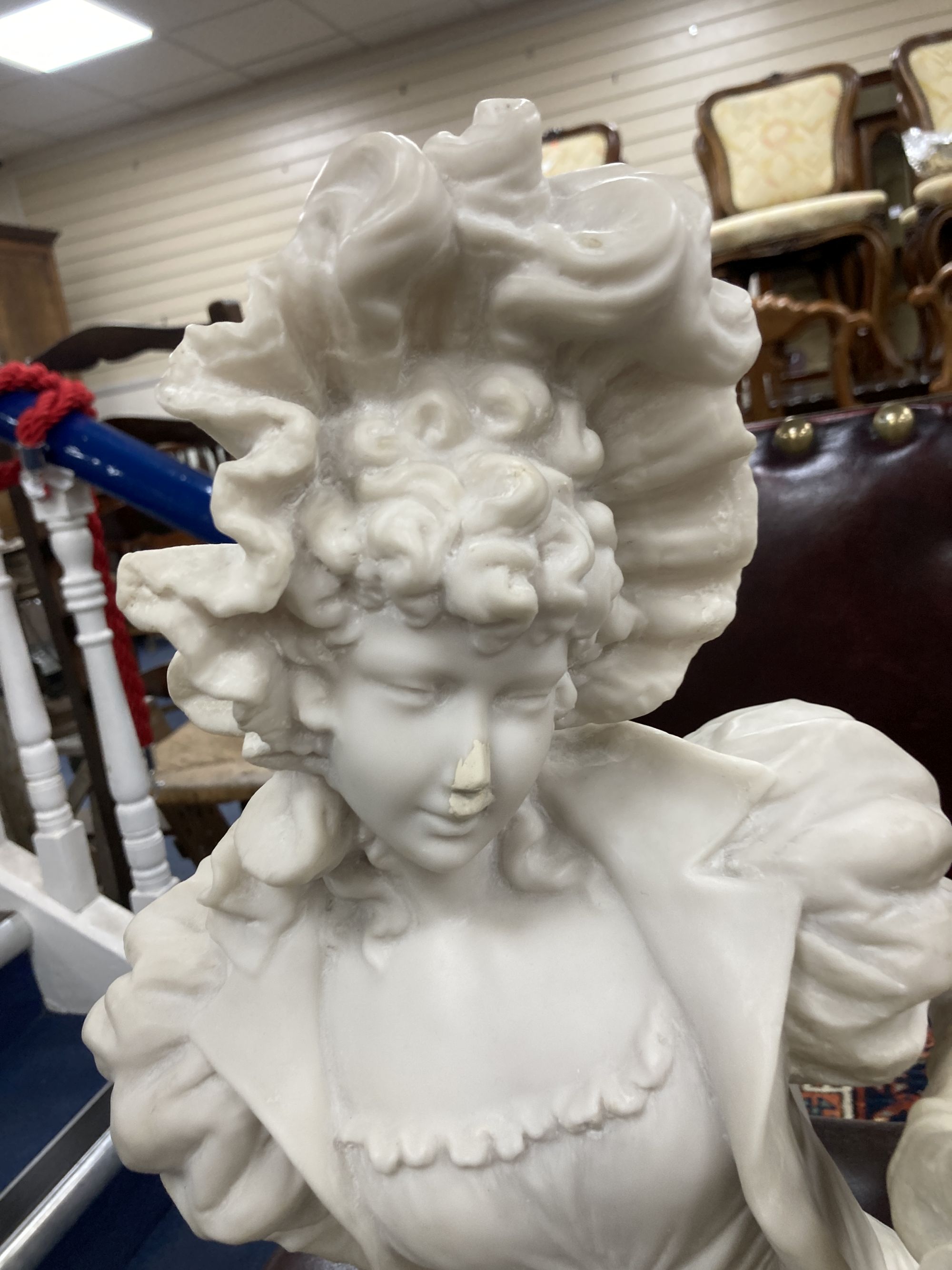 A pair of resin marble seated figures of a Dandy and a Dandizette on ebonised plinths